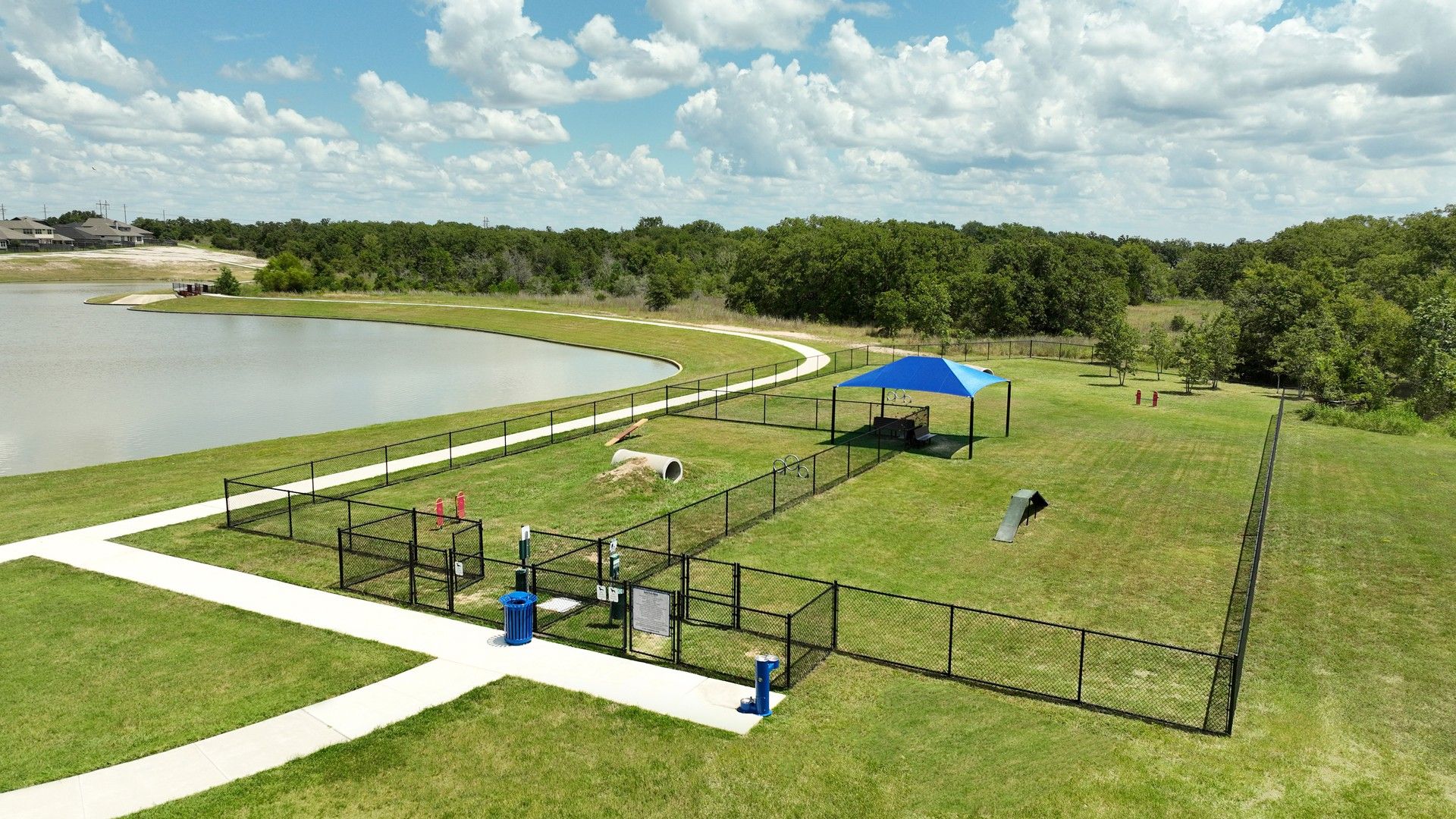 Enjoy a serene dog park with fenced play areas and a tranquil pond in Southern Pointe, College Station.