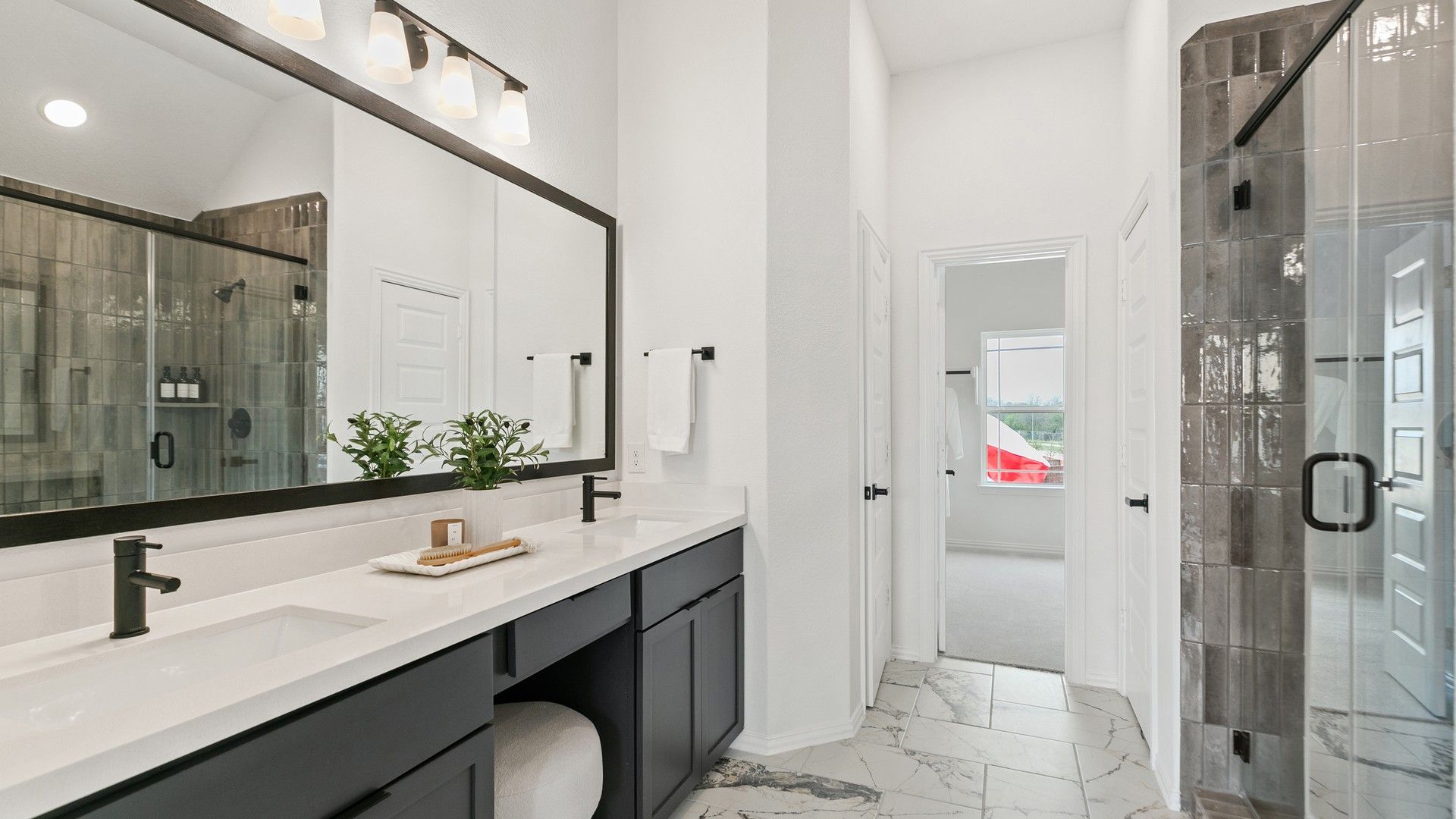 Sleek marble floors and opulent finishes in this Park at Eldridge bath exude luxury and sophistication.