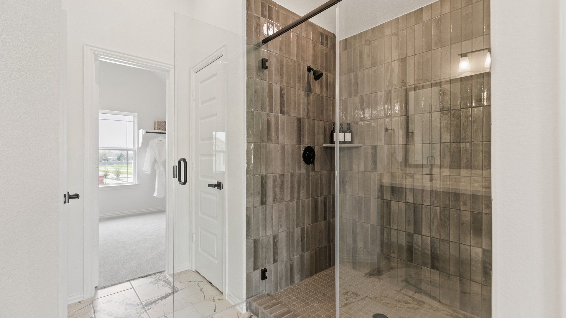 Exquisite brown tile shower with sleek glass door in Park at Eldridge, offering modern elegance.