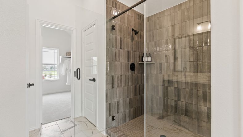 Exquisite brown tile shower with sleek glass door in Park at Eldridge, offering modern elegance.