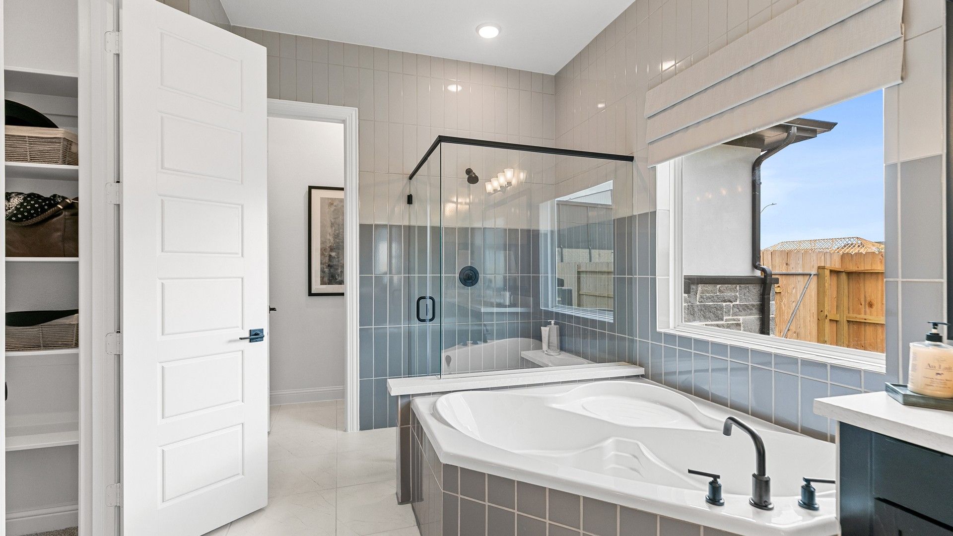 Beamer Villas bathroom boasts a chic soaking tub, seamless glass shower, and elegant tilework.