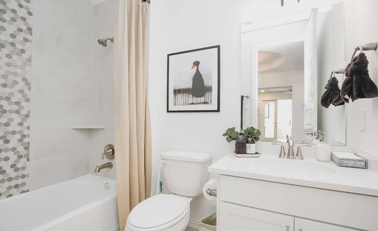 Luxurious bathroom features chic hexagonal tiles and premium fixtures in the Cypress Green community.