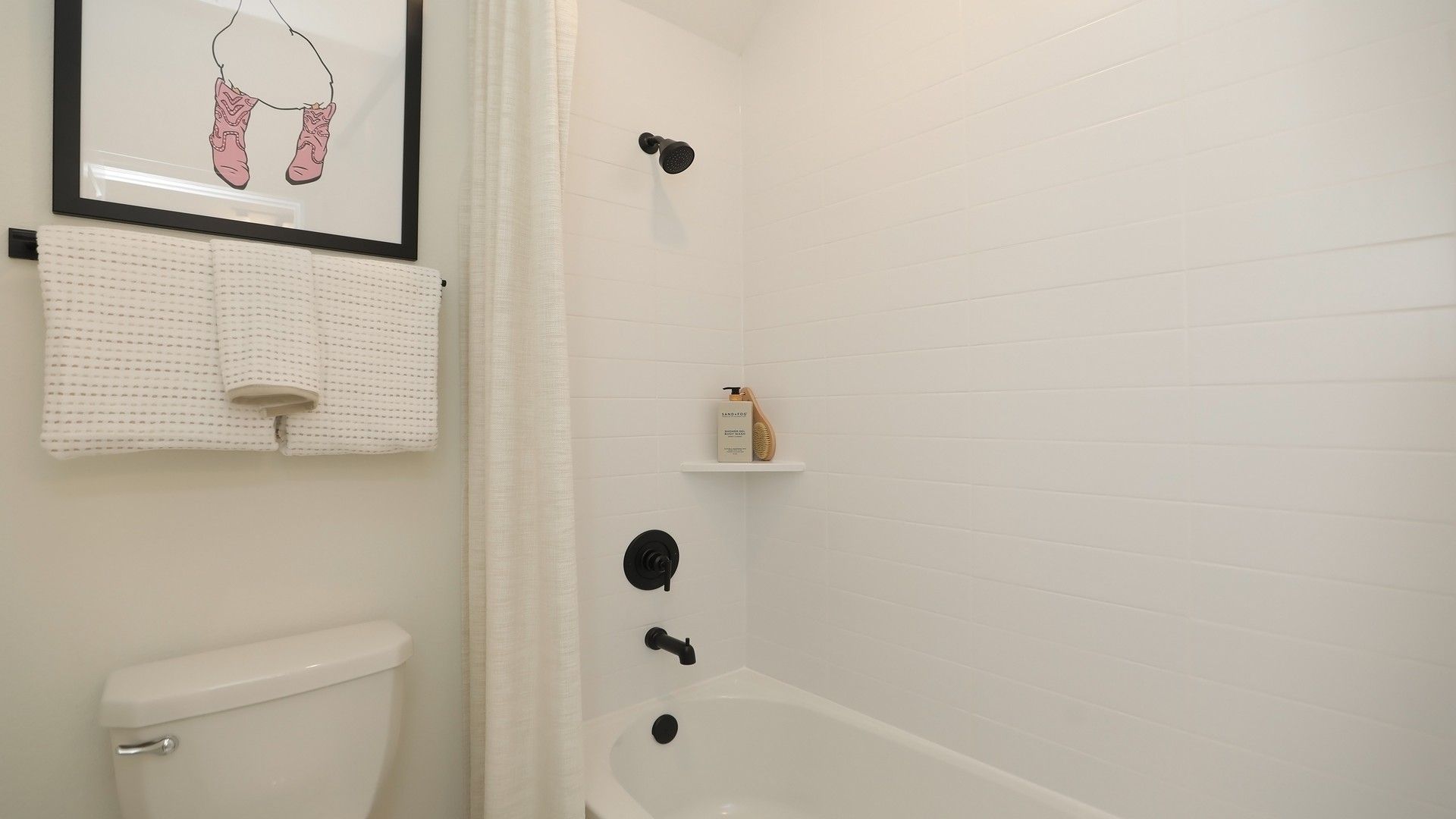 Immerse in luxury with sleek matte black fixtures and pristine white tiling in Brookewater.