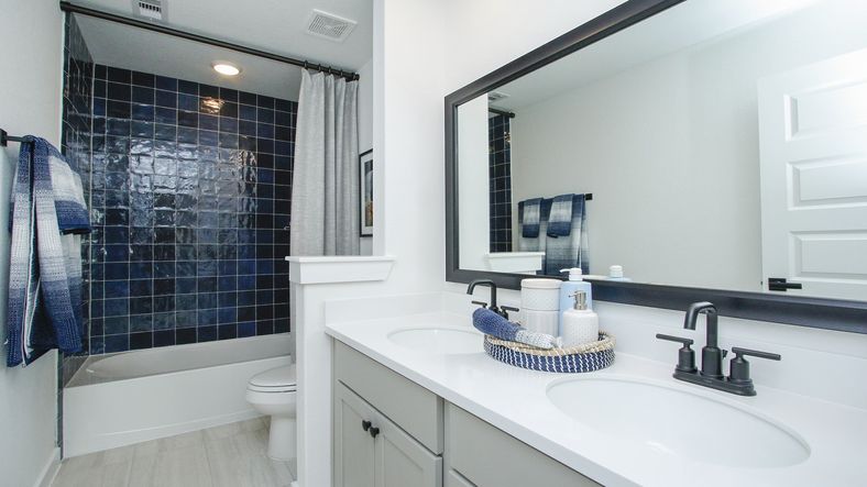 Exquisite bathroom featuring elegant navy tiles and dual sinks at Colony at Pinehurst.