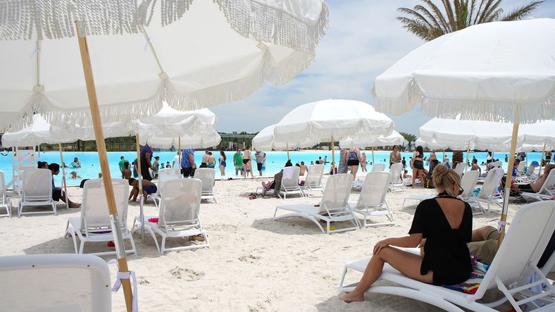 Experience Sunterra's exquisite poolside beach with elegant white umbrellas and serene blue waters.