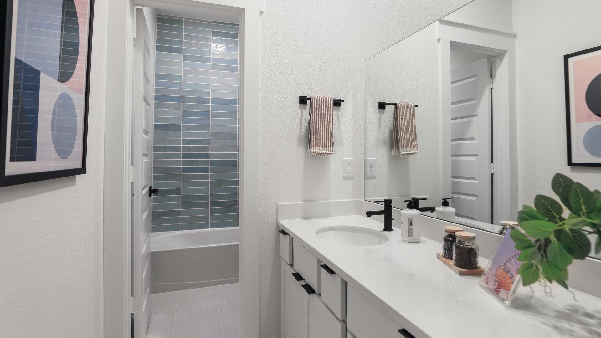 Experience refined elegance with sleek countertops, chic black fixtures, and contemporary art in Mostyn Springs.