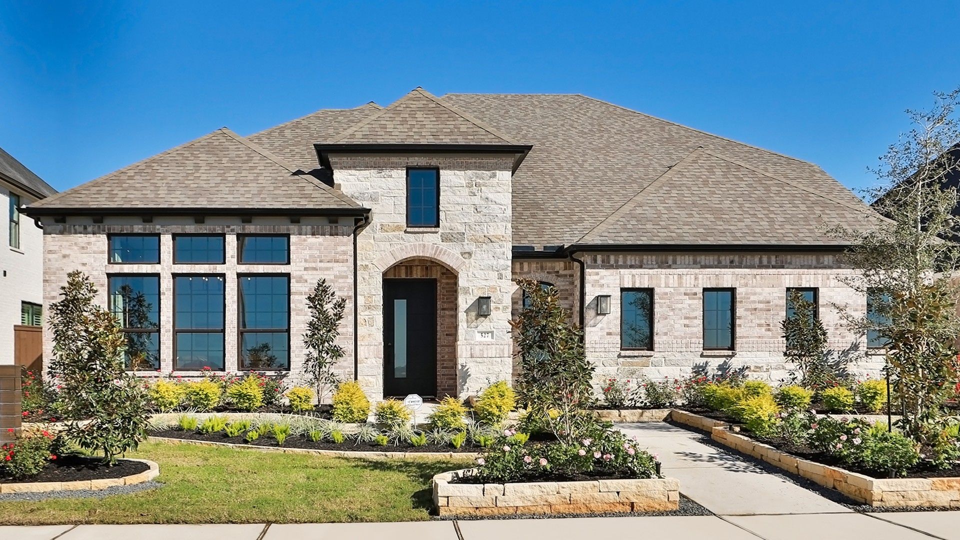 Admire the striking brick facade, expansive windows, and gabled roof in the serene Brookewater community.