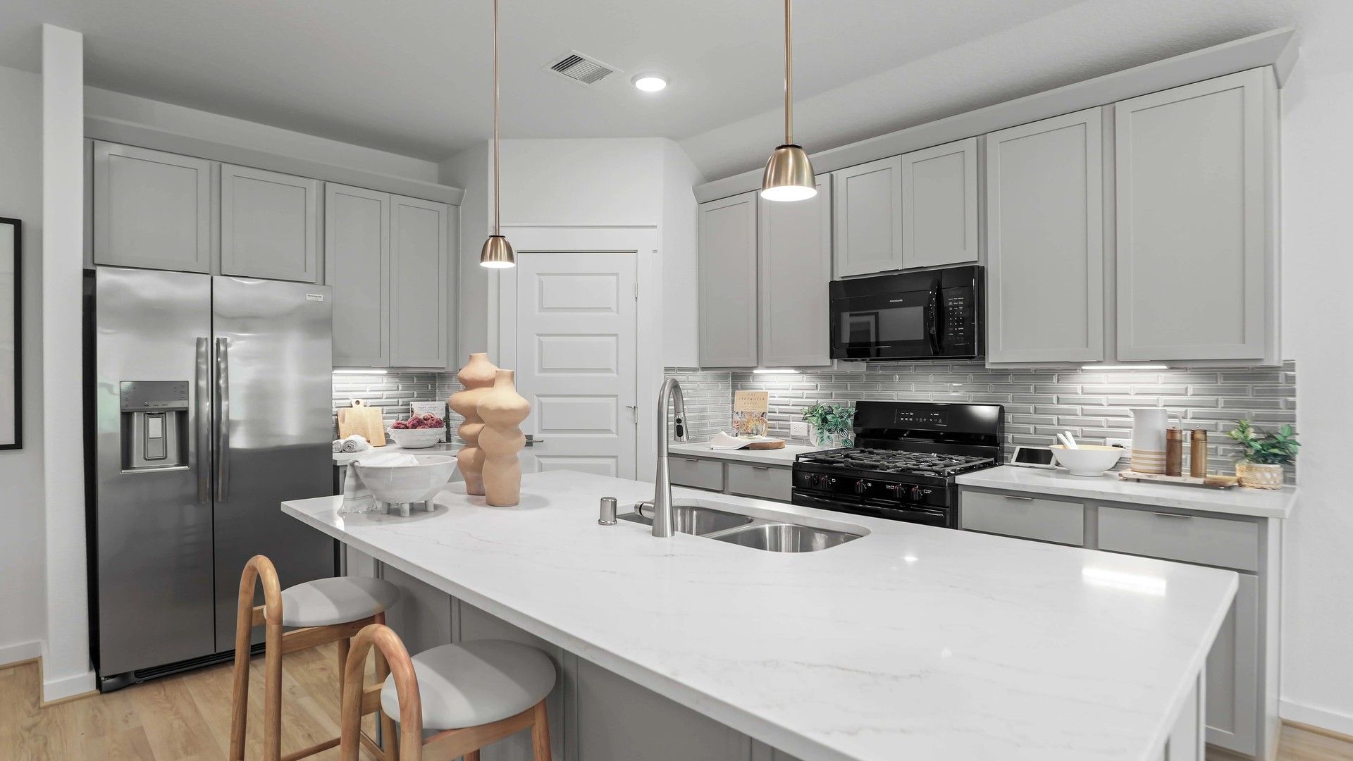 Experience luxury in Mostyn Springs with a marble kitchen island and sleek cabinetry defining elegance.