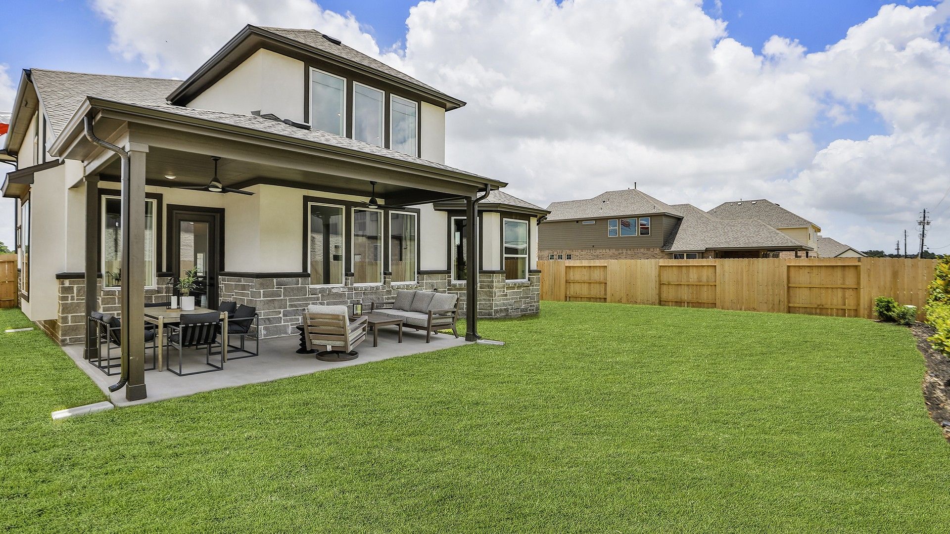 Elegant stone and stucco facade with a chic covered patio. Beamer Villas. Luxurious design elements.
