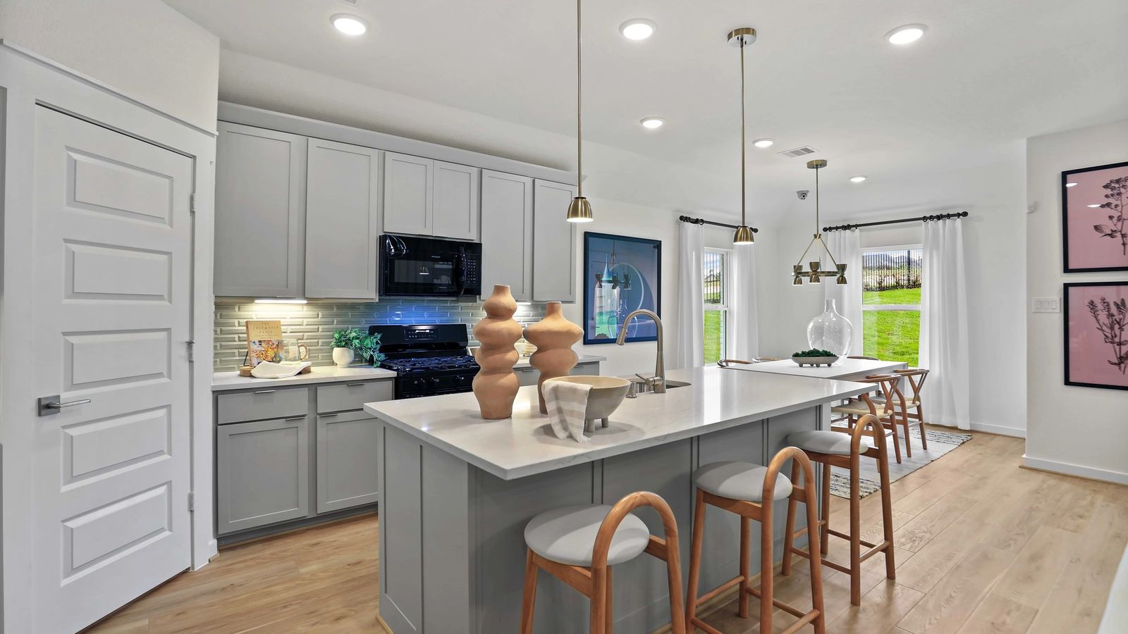 Elegant gray cabinetry and polished quartz island enhance this kitchen's modern charm in Mostyn Springs.