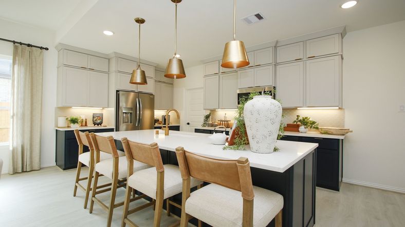Elegant kitchen with quartz countertops, luxe pendant lighting, and custom cabinetry in The Woodlands Hills.