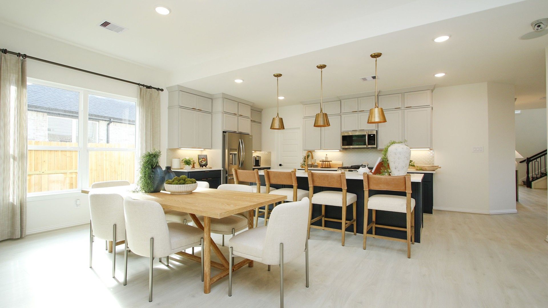 Experience luxury in The Woodlands Hills with sleek cabinetry, elegant pendant lighting, and refined wood flooring.