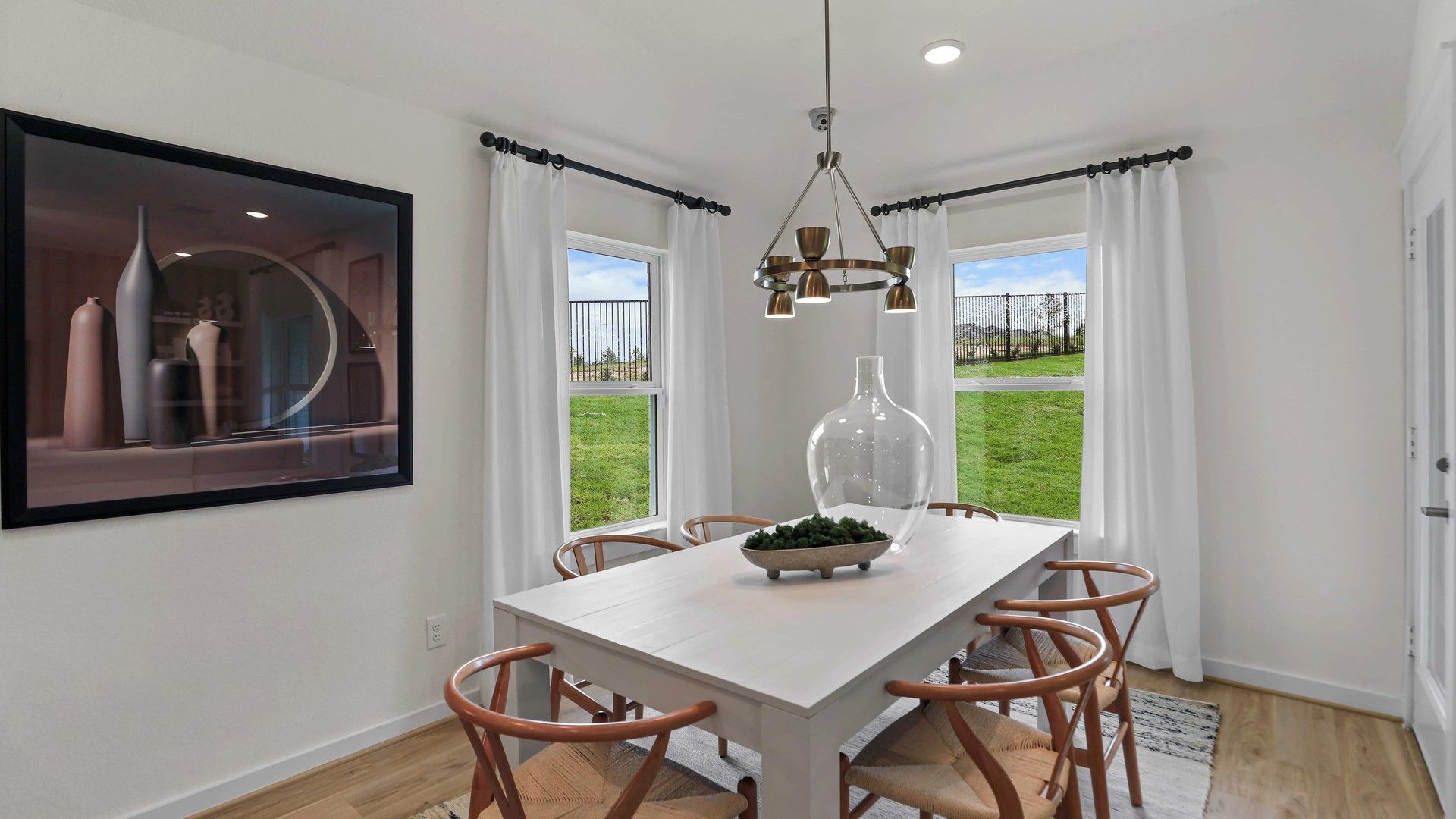 Elegant dining room with natural light, sophisticated chandelier, and refined wood floor in Mostyn Springs.