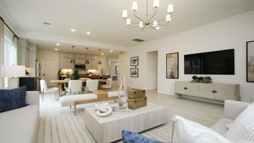 Luxurious open-plan living with chic chandelier and sleek design in The Woodlands Hills.