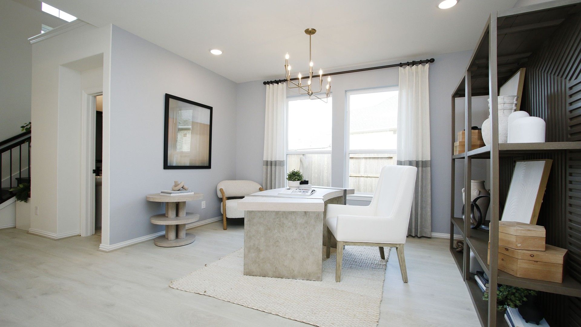 Luxurious office space with chic chandelier, expansive windows, and sleek shelving in The Woodlands Hills.