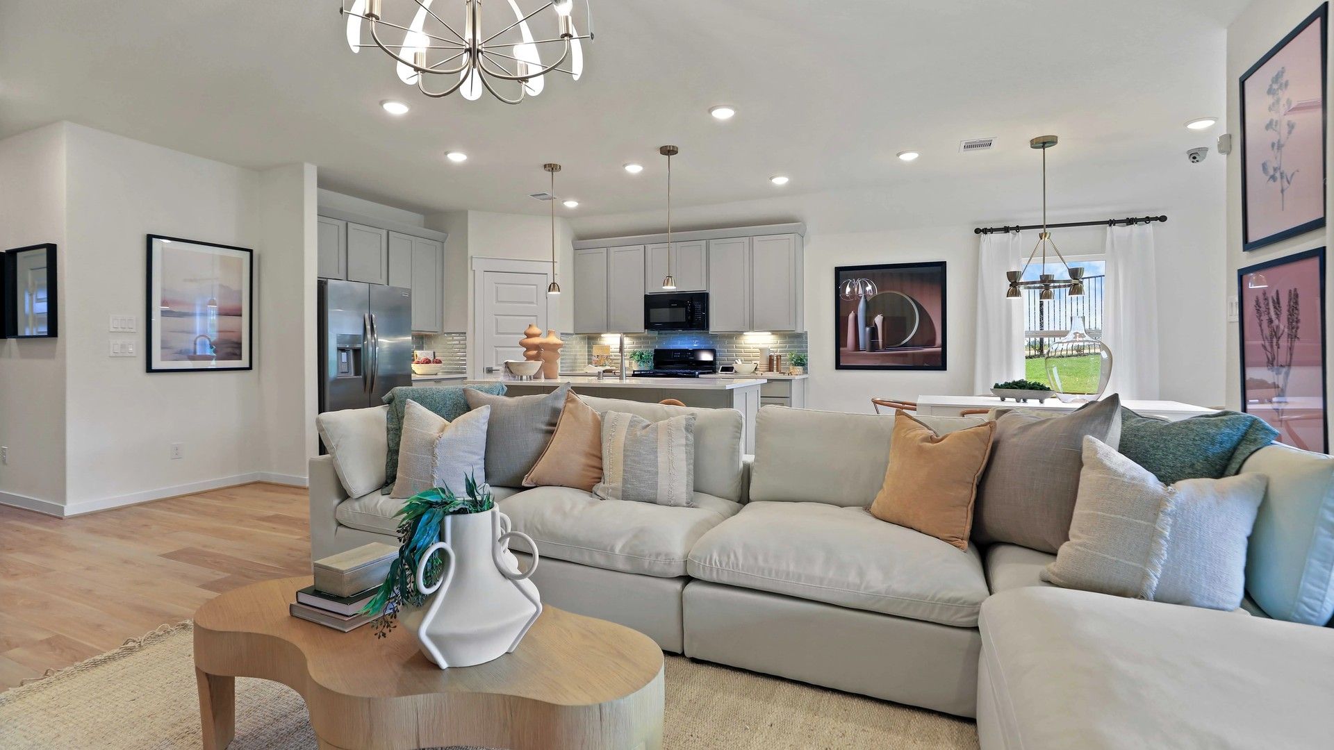 Luxurious open layout with elegant chandelier and gourmet kitchen in Mostyn Springs exudes refined sophistication.
