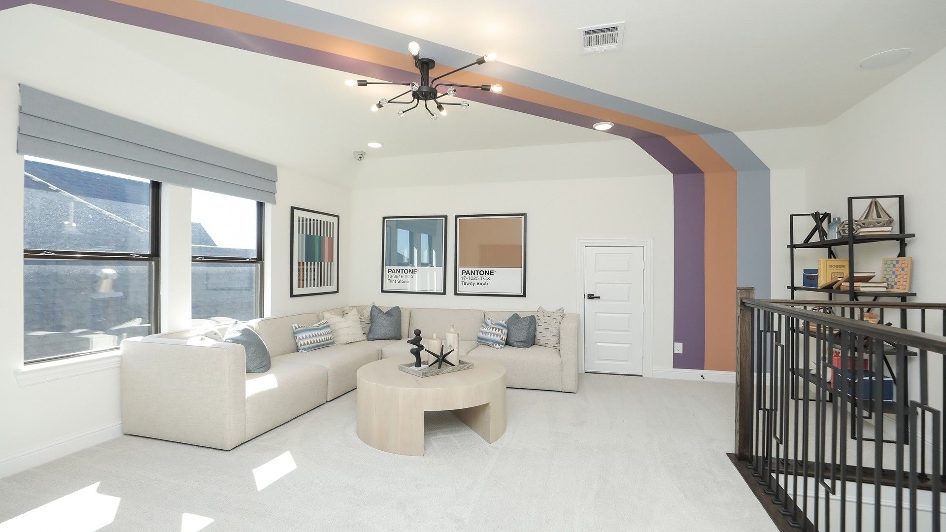 Experience luxury in Brookewater with a plush, neutral sofa, bold accent beams, and elegant railing.