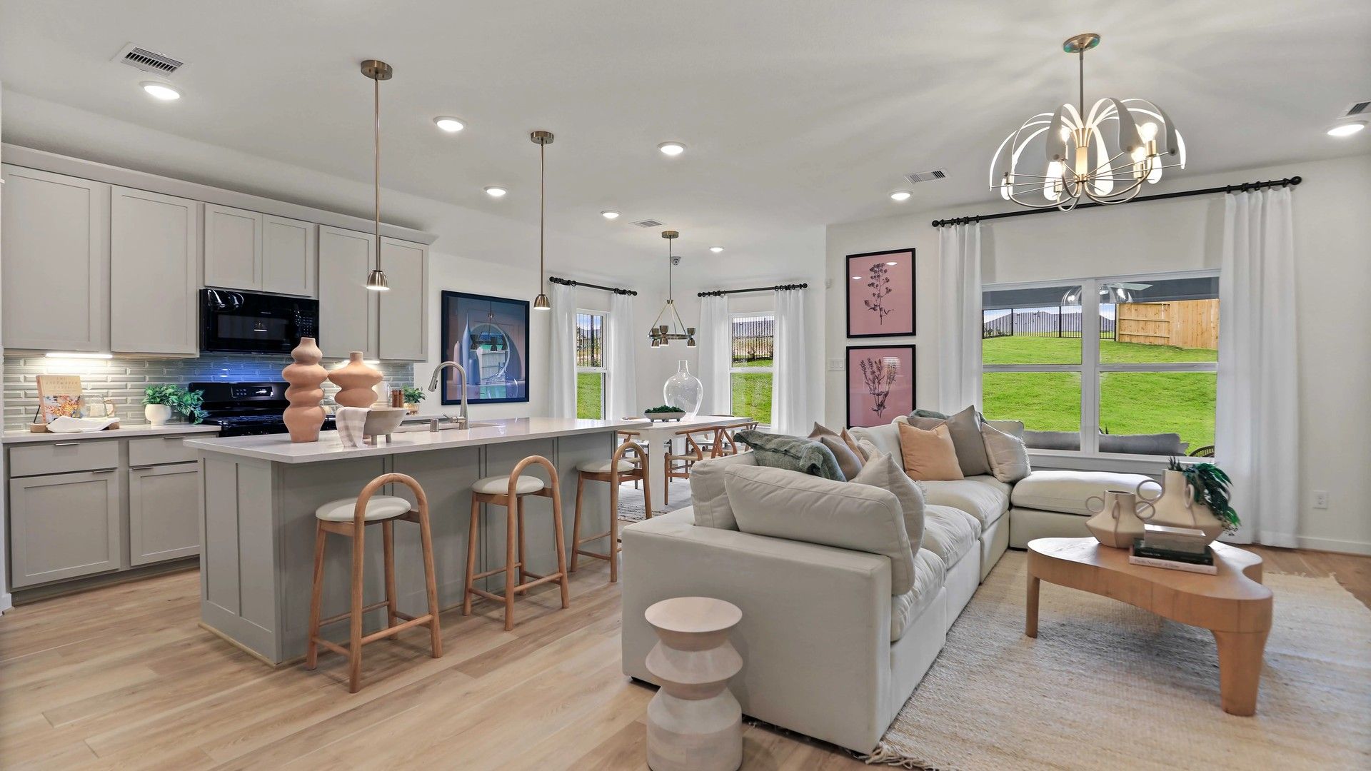 Luxurious open layout in Mostyn Springs featuring high-end lighting, chic kitchen island, and large windows.