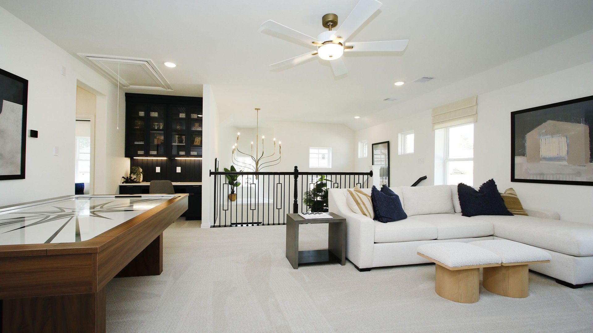 Luxurious open living area with chic black cabinetry, plush white seating, and ambient lighting in The Woodlands Hills.