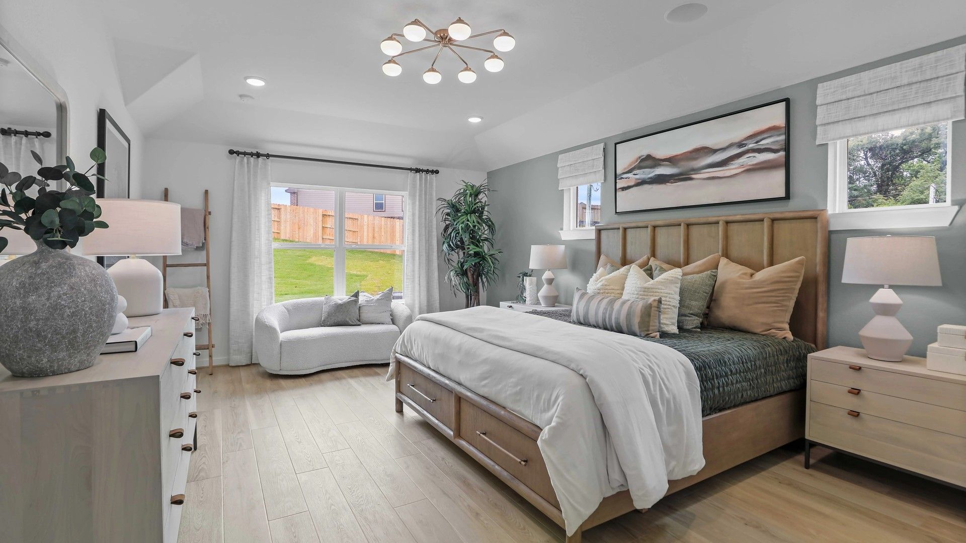 Expansive bedroom boasts hardwood floors, chic lighting, and serene views in Mostyn Springs.