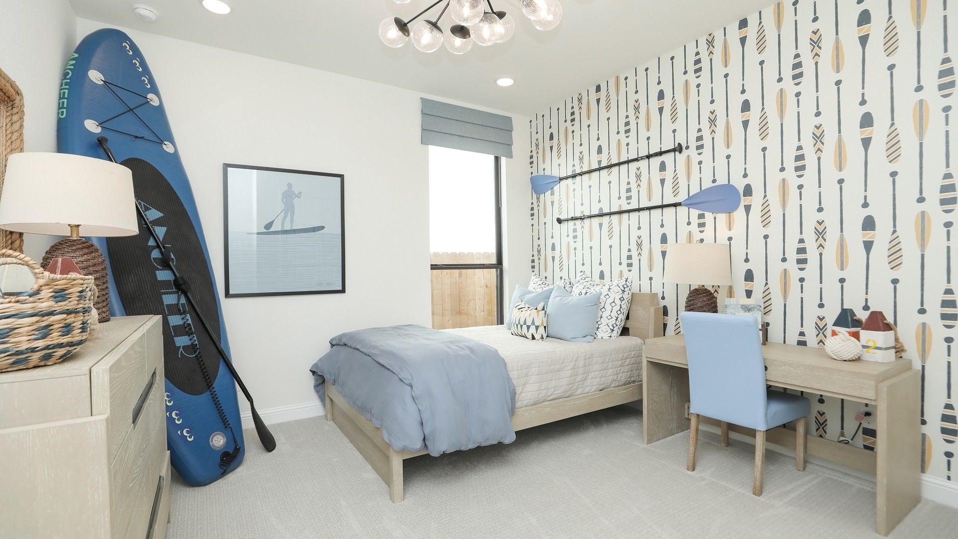 Paddle-themed wallpaper and chic chandelier in Brookewater make this bedroom an exquisite retreat.