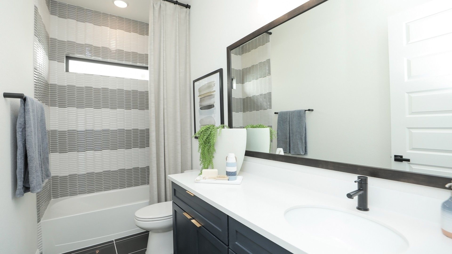 Luxurious matte black finishes meet exquisite textured tiles in Brookewater's sophisticated bathroom design.