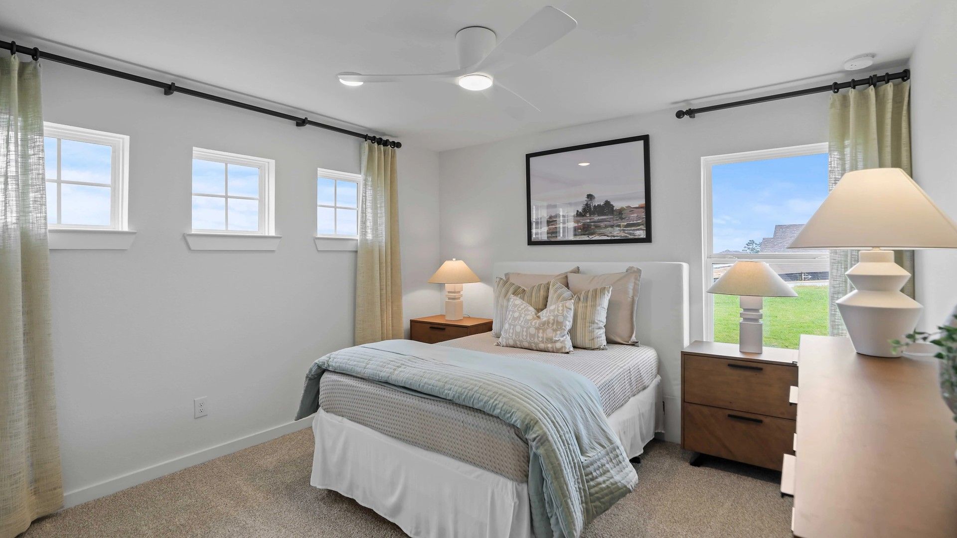 Sophisticated bedroom features plush carpet, sleek ceiling fan, and ample natural light in Mostyn Springs.