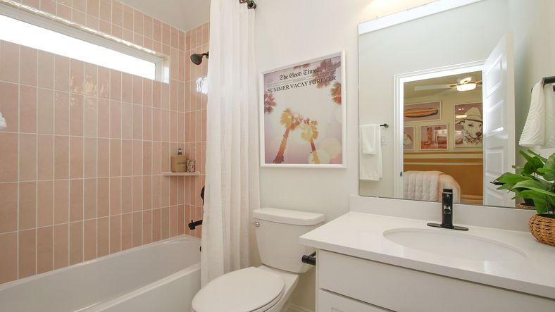 Luxurious bathroom features elegant pink tiles and modern fixtures in The Woodlands Hills.