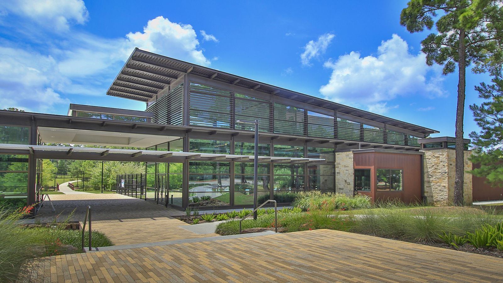 Sleek glass facade and elegant louvered panels define this Woodlands Hills architectural marvel.