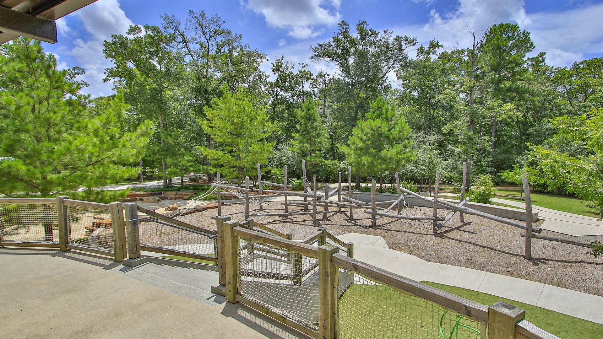 Experience refined outdoor play with artisanal wood structures amidst lush forest in The Woodlands Hills.