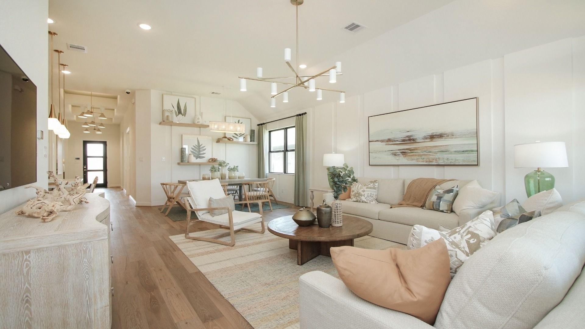 Elegant Sunterra living room boasts chic lighting, seamless hardwood floors, and refined finishes in Houston.