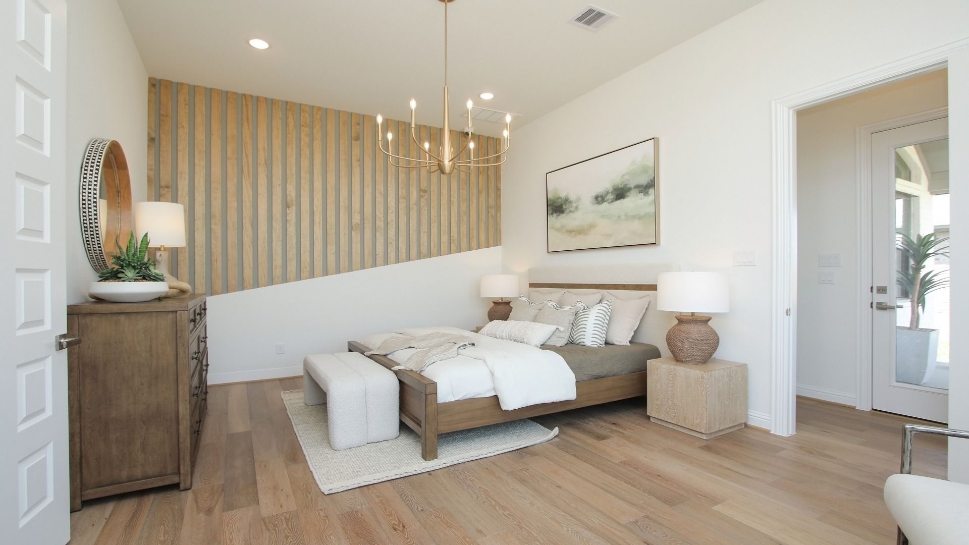 Luxury Sunterra bedroom boasts a tray ceiling, sophisticated accent wall, and plush bedding for a serene retreat.