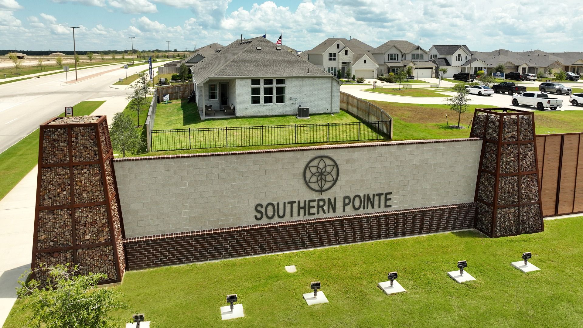 Elegant Southern Pointe entrance with modern architecture and lush landscaping in College Station.