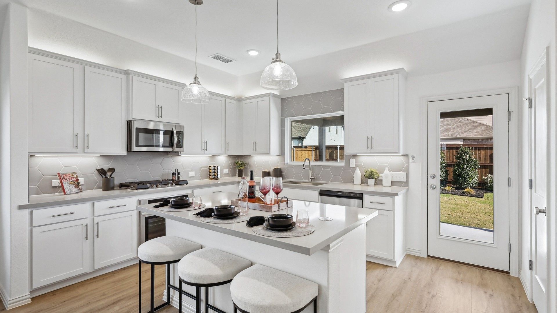 Elegant Bel Air Village kitchen showcases sleek white cabinetry and chic hexagonal backsplash for a modern feel.