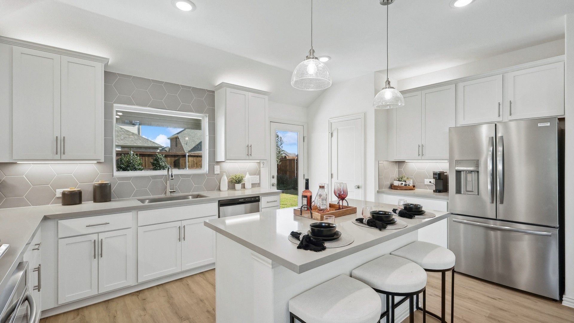 Sleek white cabinetry, chic hex tile backsplash, and premium stainless appliances in Bel Air Village.