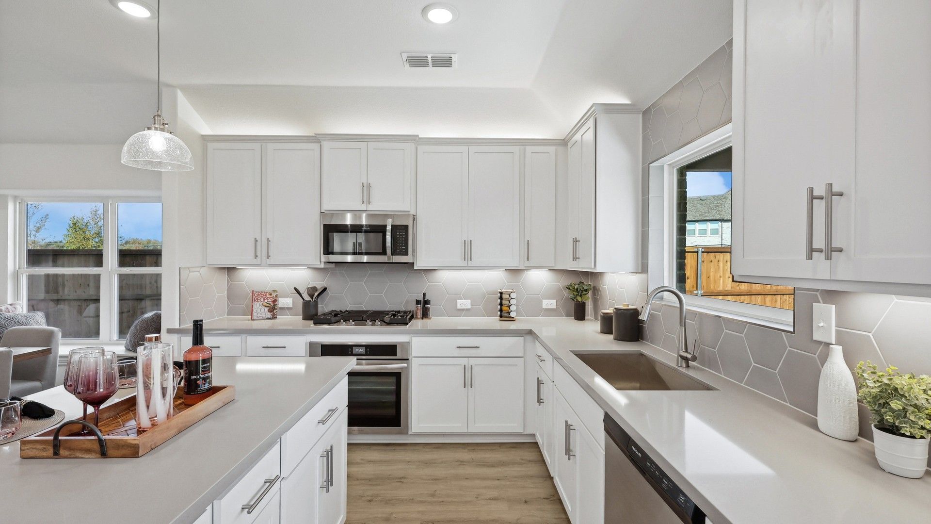 Elegant kitchen features sleek white cabinetry and striking hexagonal backsplash in Bel Air Village.