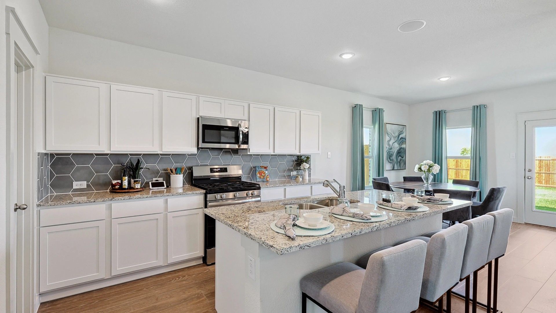 Experience luxury with granite countertops and sleek hexagonal tiles in this exquisite Patriot Estates kitchen.