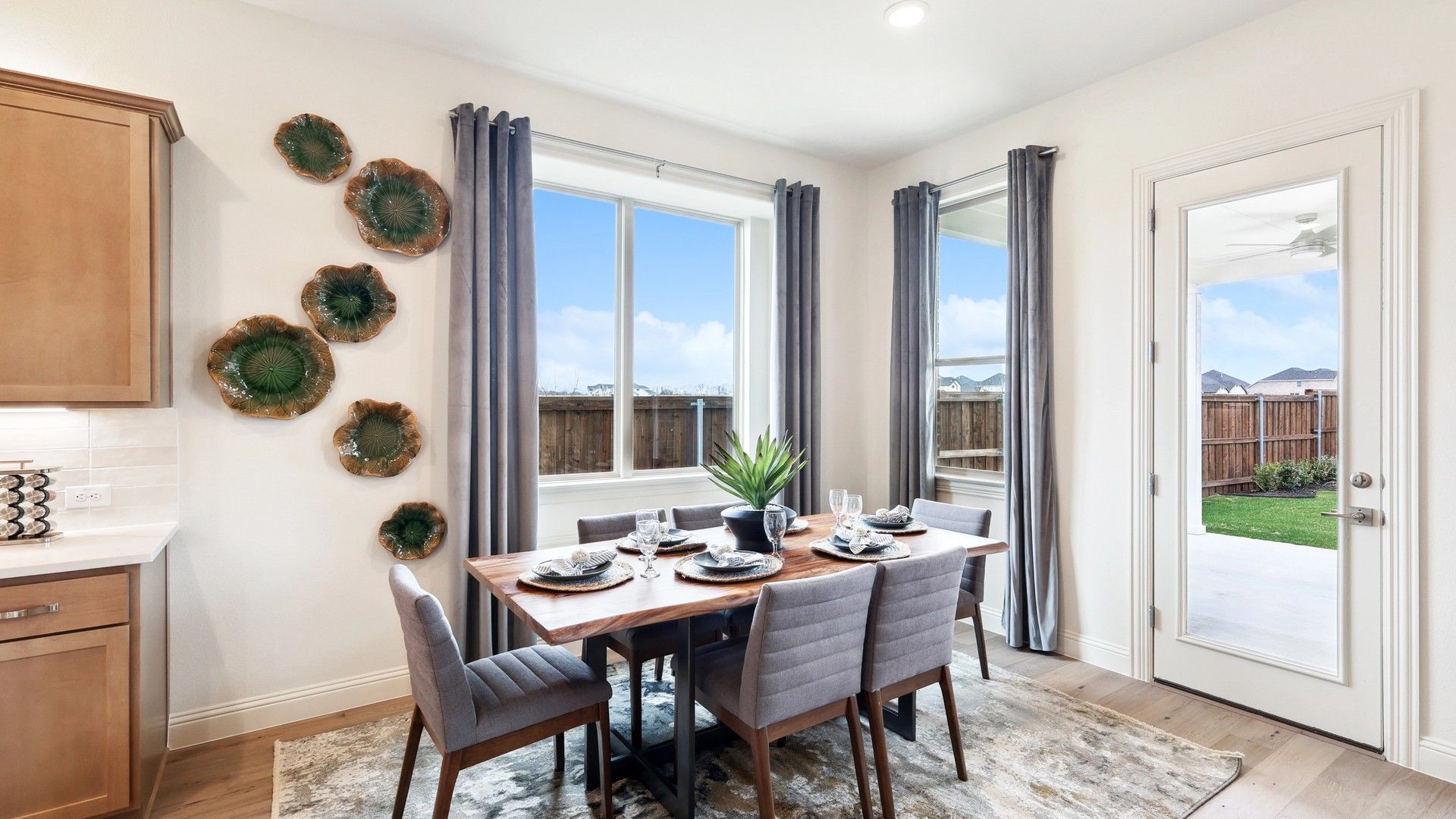 Sophisticated dining area with exquisite wood table and lush garden views in The Oaks community.