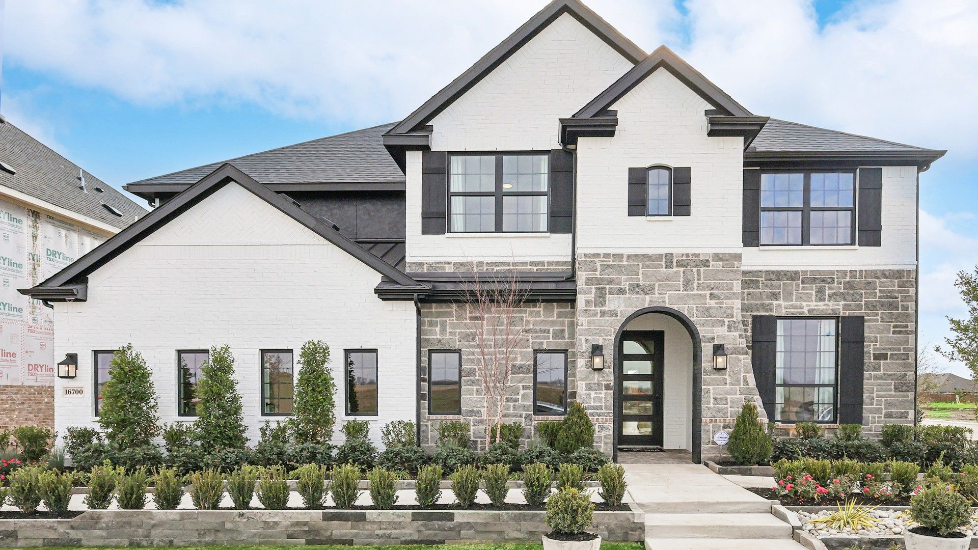 Sophisticated brick and stone facade with an arched entry in Green Meadows.