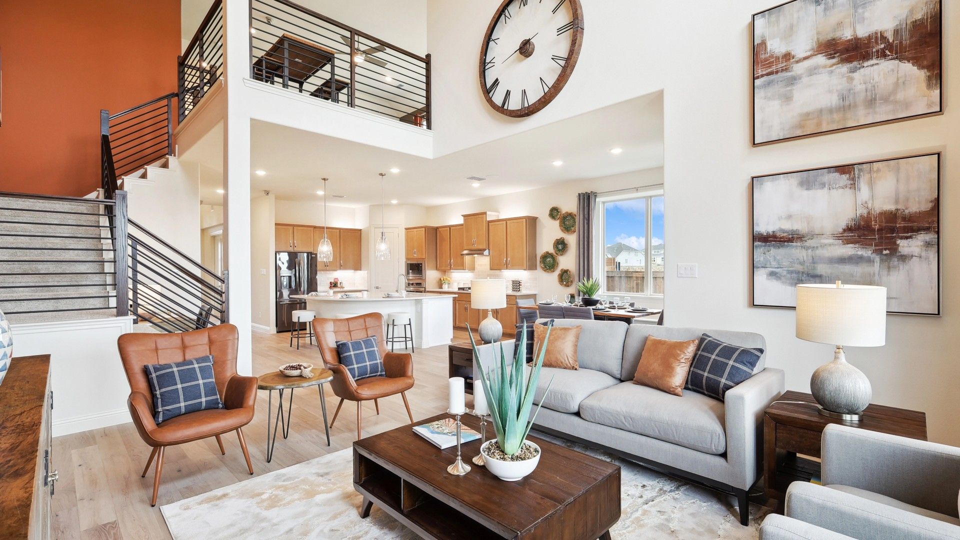 Elegant open-concept living with a striking wall clock and designer finishes in The Oaks.