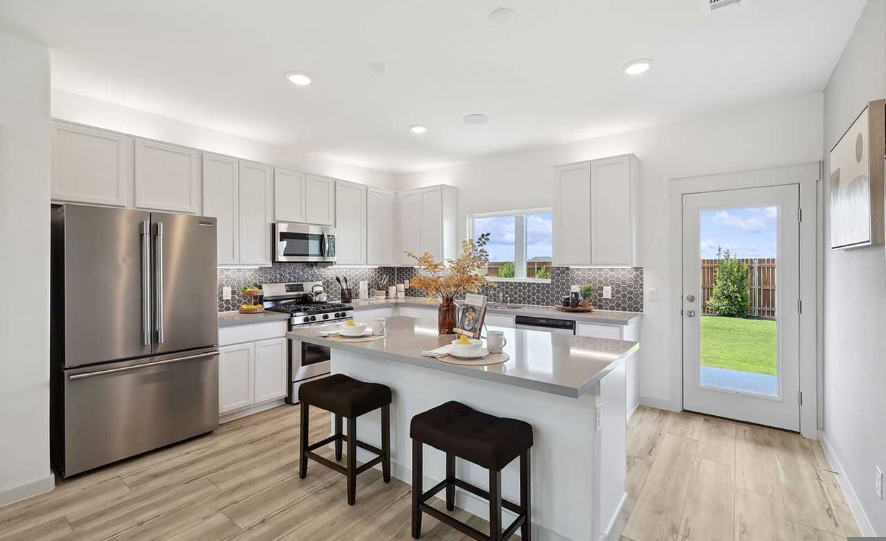 Sleek quartz countertops and stainless appliances elevate this Walden Pond home's kitchen aesthetics.