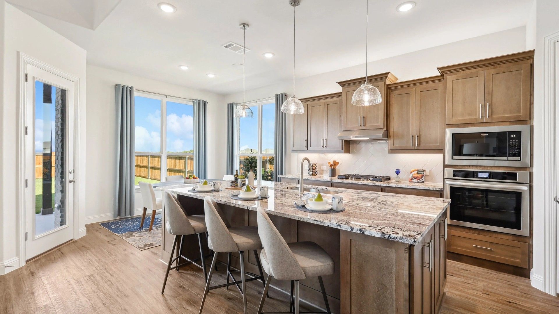 Admire Ridge Crossing's luxurious kitchen with pristine granite counters, elegant wood cabinetry, and expansive windows.