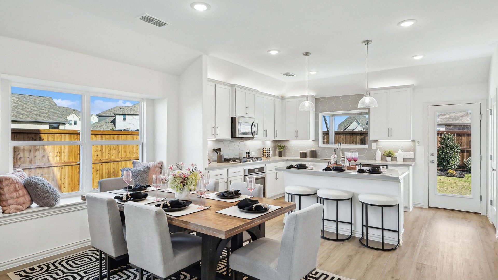 Experience elegance with sleek cabinetry, a spacious island, and a serene garden view in Bel Air Village.