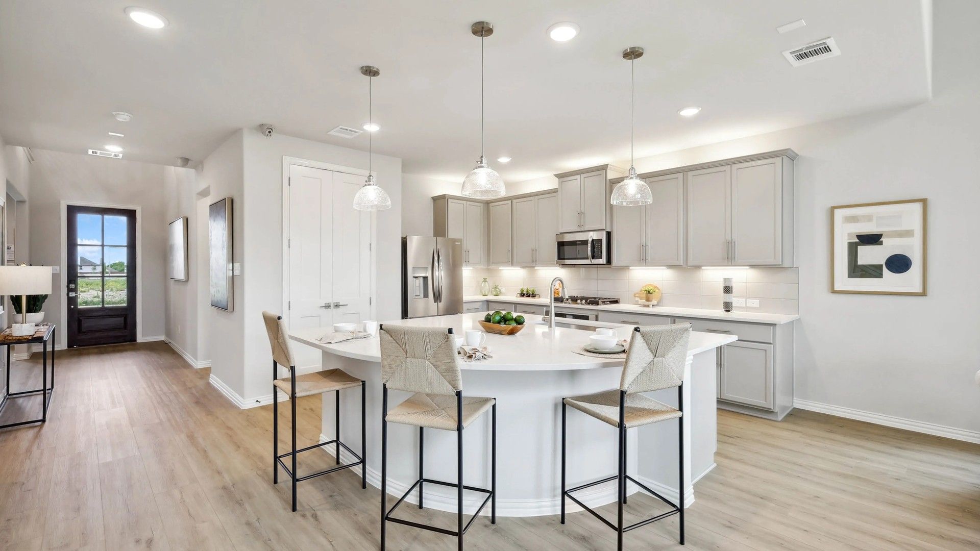Experience luxury in Hulen Trails with sleek gray cabinetry and elegant pendant lighting.