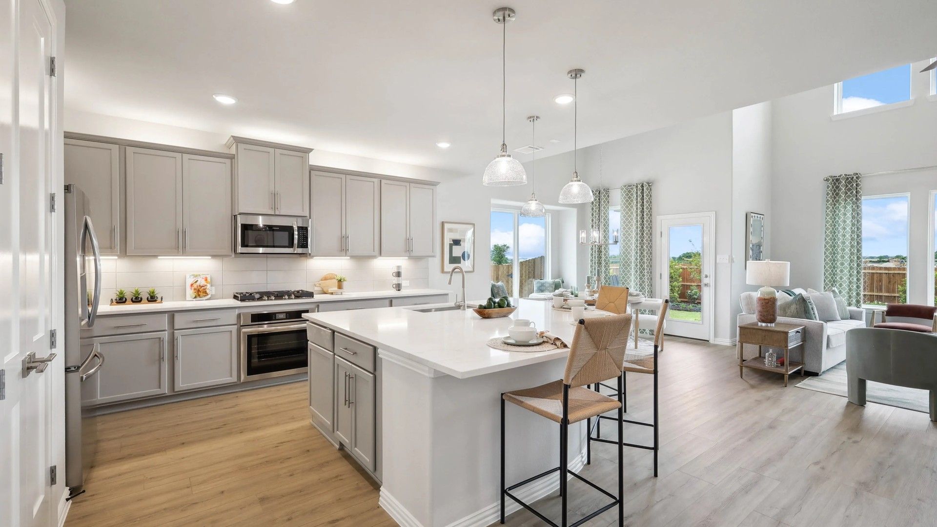 Elegant light gray cabinetry and expansive island enhance this Fort Worth home's sophisticated open layout.