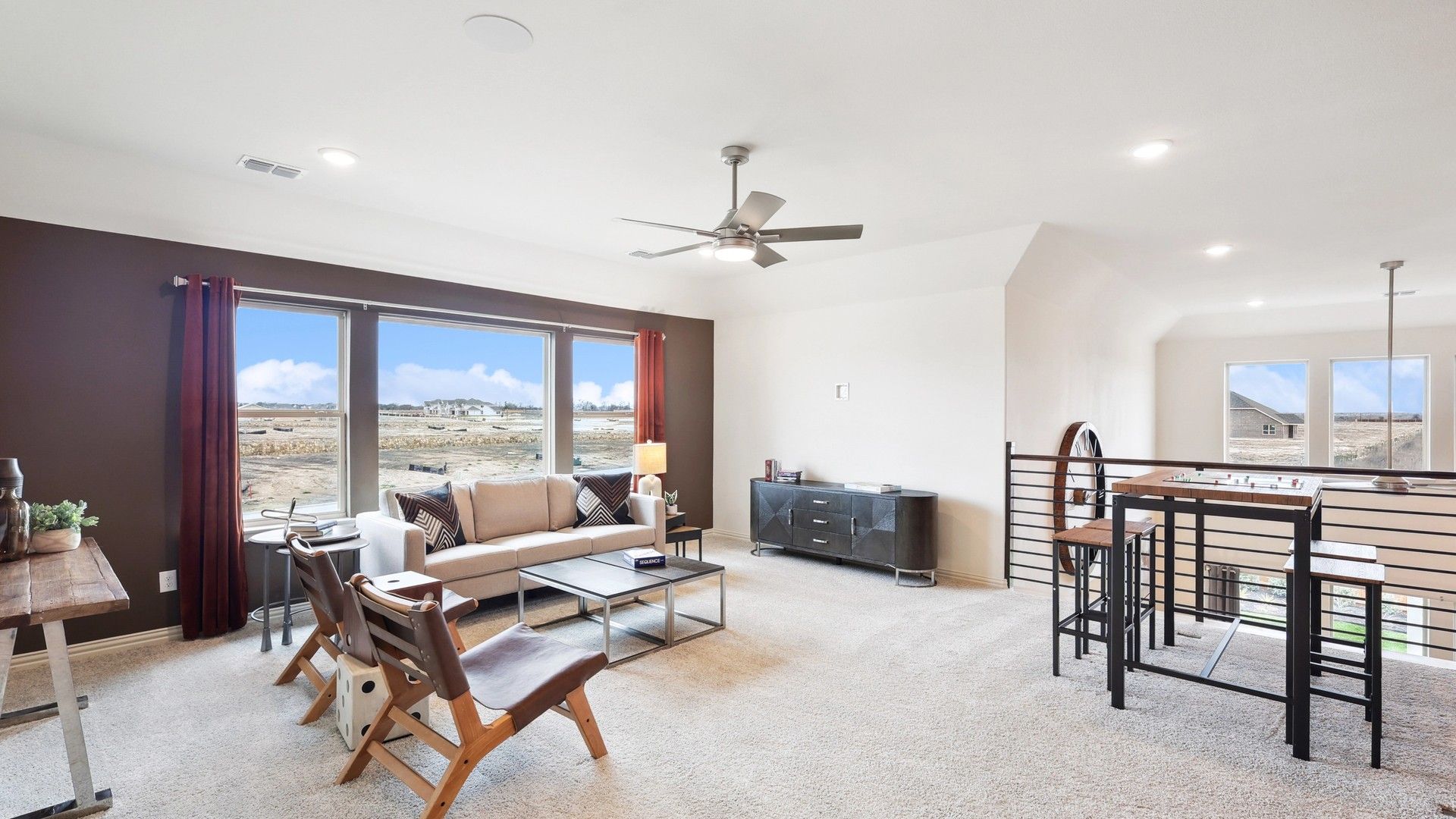 Expansive windows and sleek furnishings define this chic living space in The Oaks community.