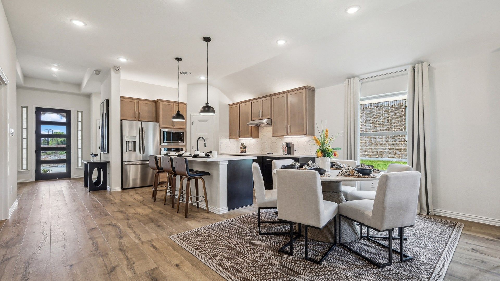 Elegant wood floors and sleek cabinetry highlight this Churchill home's modern kitchen and dining area.