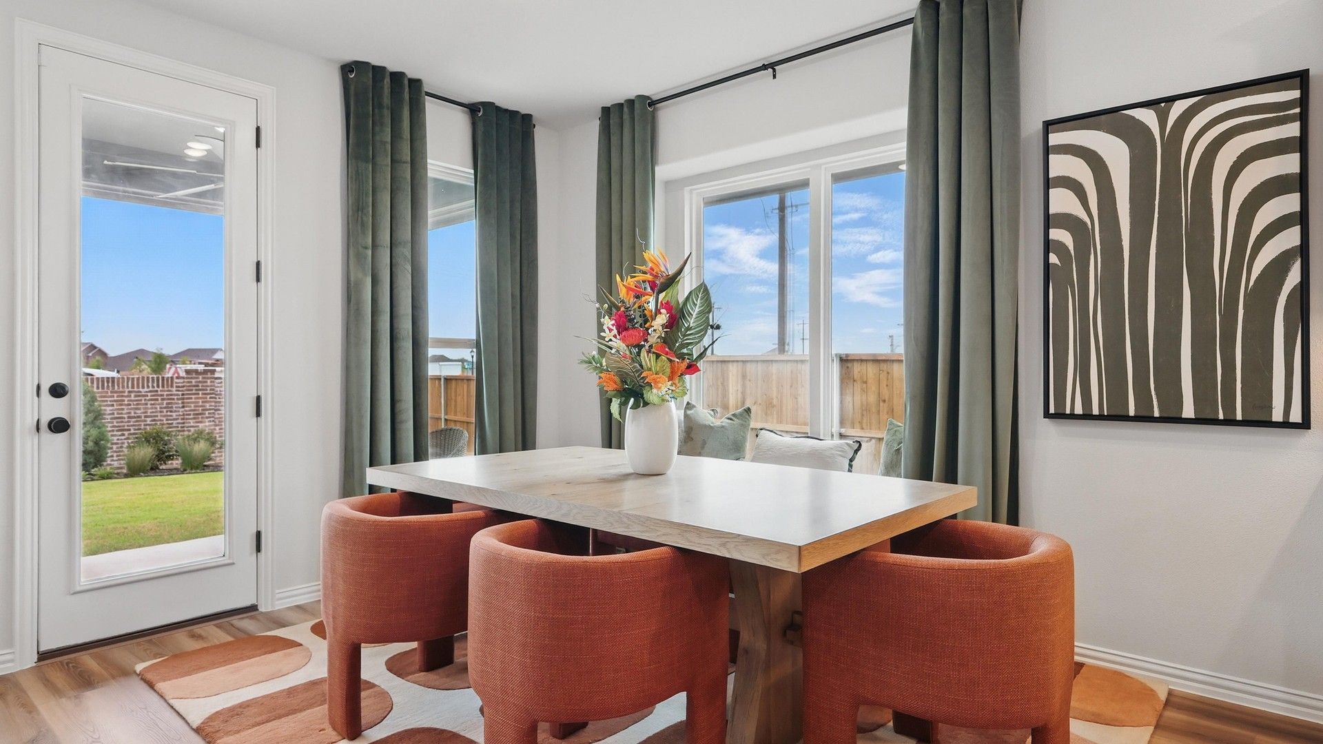Chic dining space features modern table, plush chairs, and garden view in luxurious Westridge enclave.
