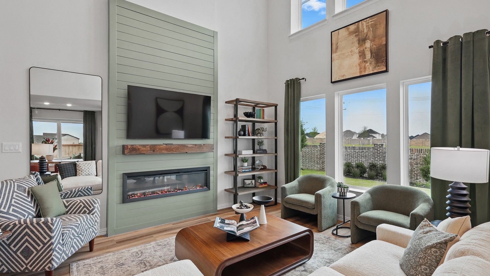 Revel in Westridge's elegant living room showcasing a striking green shiplap fireplace and expansive windows.