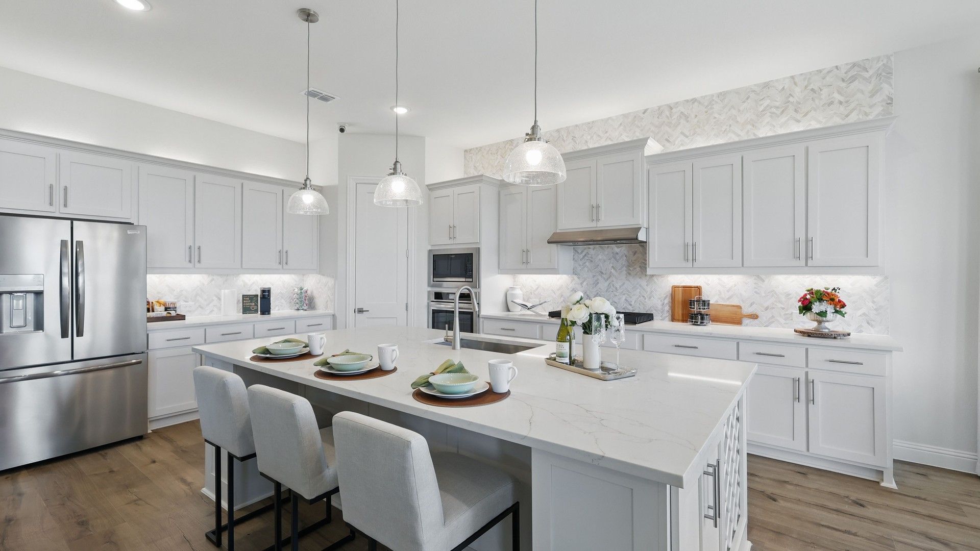 Luxurious marble island and herringbone backsplash define this Rio Vista kitchen's elegance.